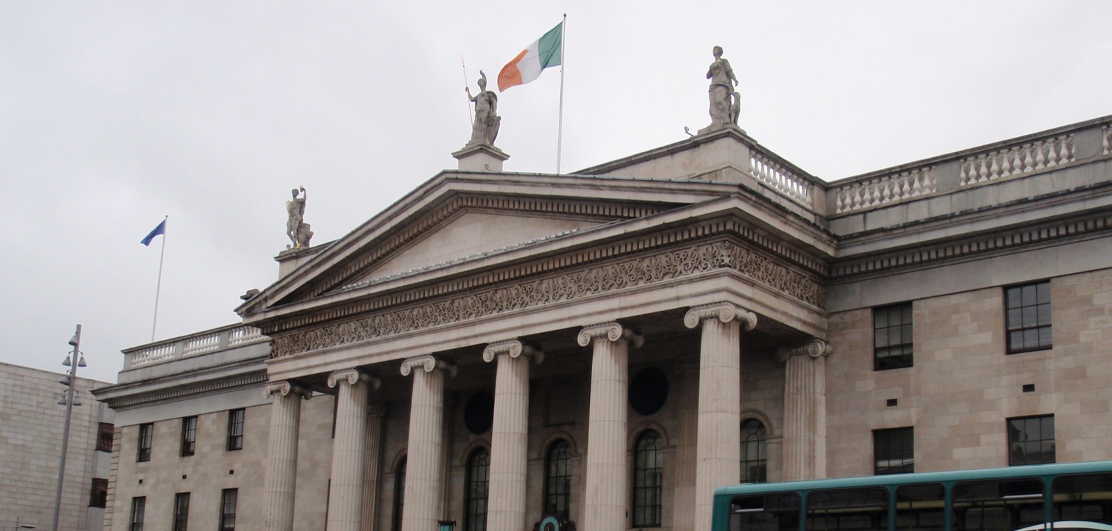 Die irische Trikolore weht links von ihrem Mast auf dem Dach des General Post Office in Dublin, daneben eine EU-Flagge